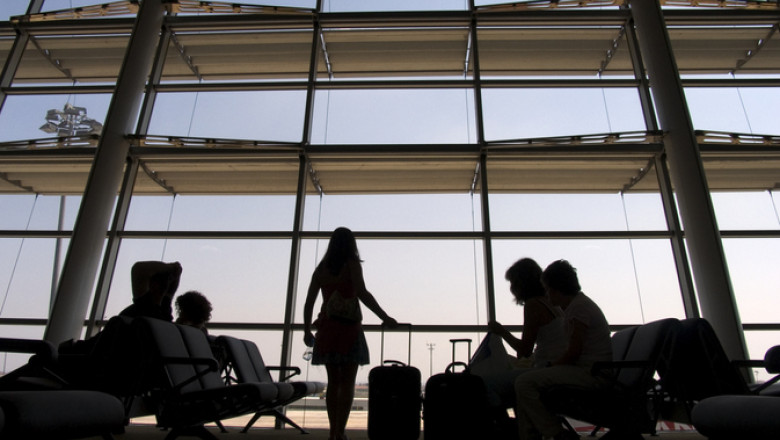 siluete de oameni cu bagaje in aeroport