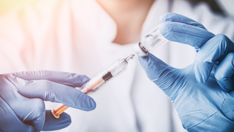 o asistenta trage vaccin dintr-un flacon intr-o seringa