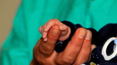 mana de copil care strange mana unui medic