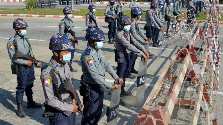 politisti inarmati in spatele unor bariere de protectie blocheaza un drum