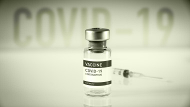doză de vaccin anti-COVID şi o seringă pe fundal