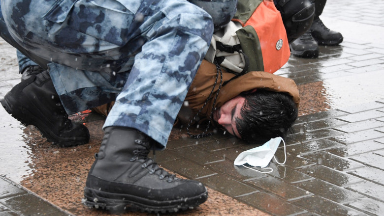 Un bărbat pus la pământ cu brutalitate de polițiștii ruși. Lângă el, masca de protecție anti-covid i-a căzut în timpul altercației.