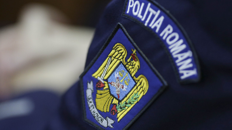Ecuson al Poliției Române pe mâneca uniformei.