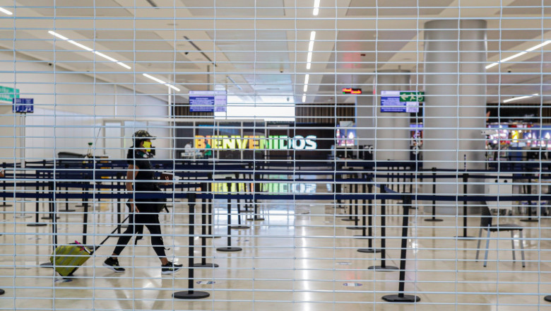 un turist trece cu bagajul prin aeroportul din cancun. imagine vazuta printre gratii