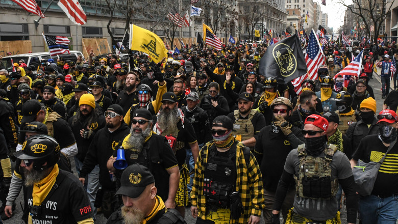 grup de bărbați, membri ai Proud Boys, îmbrăcați în negru cu galben, la un protest în Washington.