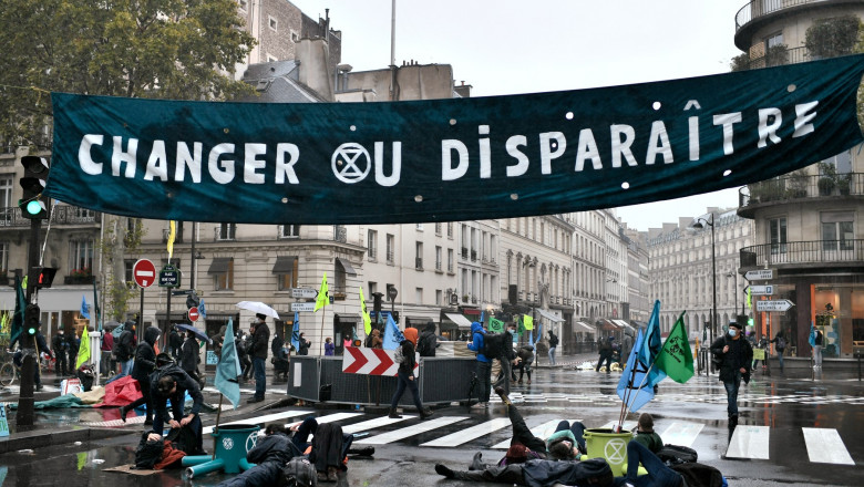 Protest al activiștilor pentru mediu, în Franța..Mai mulți participanti sunt intinsi pe sosea sub un banner
