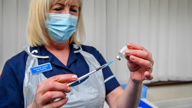 asistenta cu masca albastra care foloseste o doza de vaccin