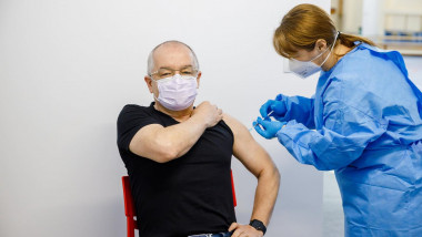emil boc poarta un tricou negru si blugi in momentul vaccinari anti-covid.
