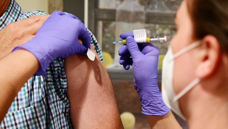 asistenta medicala face o doza de vaccin in umarul unui pacient