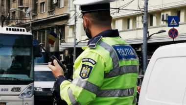 politist in trafic purtand uniforma si cu o statie in mana