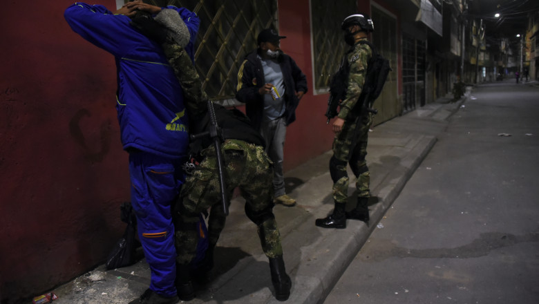 Polițiști militari din Columbia percheziționează câțiva civili pe perioada pandemiei.