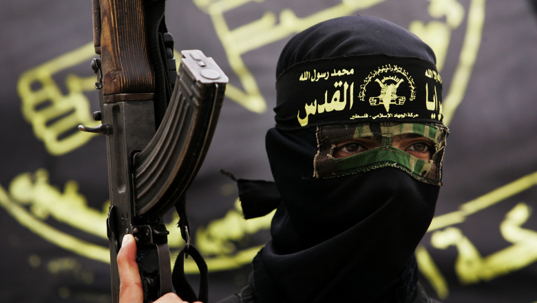 adept al gruparii stat islamic acoperit cu cagula si cu o mitraliera in mana