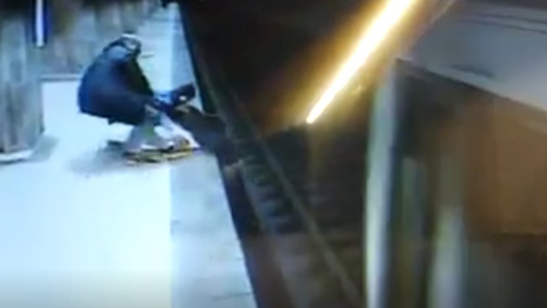 captura video - doua persoane trag pe peron o tanara care se aruncase pe sinele metroului chiar inante ca trenul sa intre in statie
