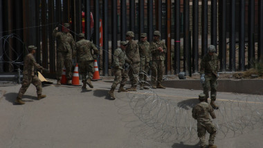 Militari americani lucrează la zidul de la frontiera dintre SUA și Mexic.
