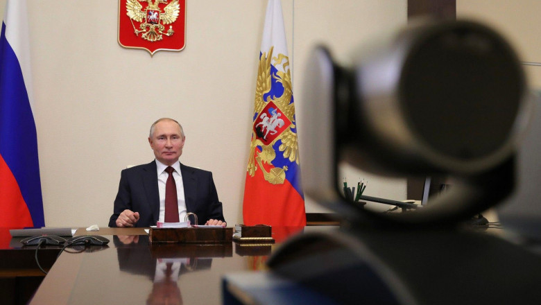 Președintele rus Vladimir Putin sta la birou in fata unei camere de luat vederi