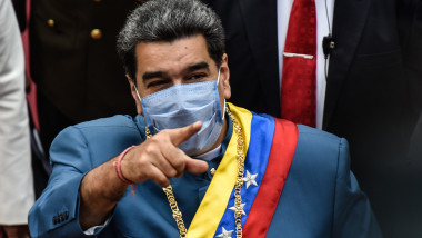 Nicolas Maduro, purtând mască și însemnele oficiale ale statului venezuelean arată cu degetul spre cameră.