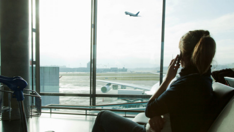 femeie care vorbeste la telefon in aeroport