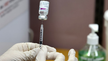 un cadru medical extrage o doza de vaccin cu o seringa
