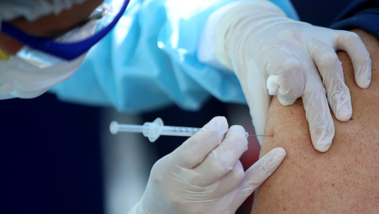 un cadru medical adminsitreaza vaccin anti-covid unui pacient