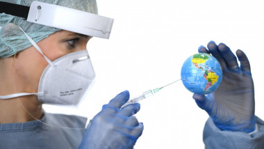 o asistenta cu o seringa de vaccin care inteapa un glob pamantesc