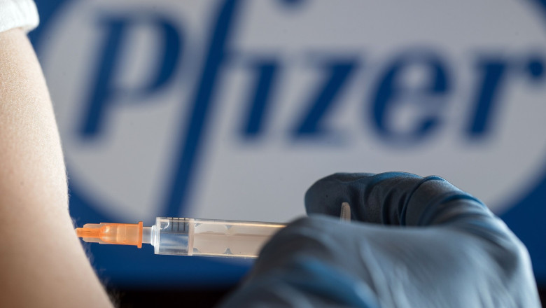 Un cadru medical umple o seringă cu ser Pfizer.