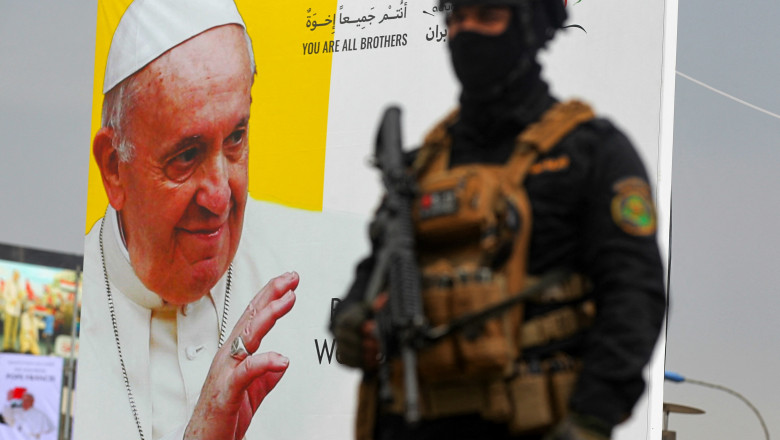 Un militar irakian lângă un afiș cu Papa Francisc.