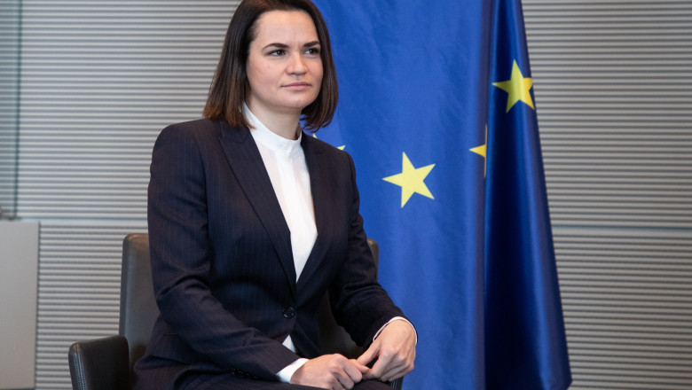 Svetlana Tihanovskaia stă pe scaun, cu steagul Uniunii Europene în spate