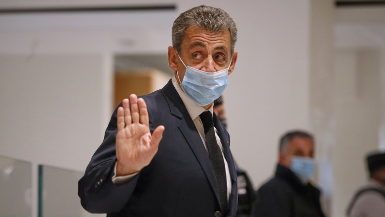 Nicolas Sarkozy, cu mască de protecție, salută presa.