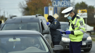 politistii verifica masinile la intrarea intr-o localitate in carantina