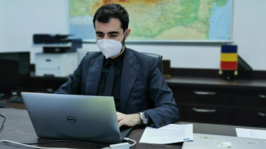 Claudiu Năsui lucrează la laptop într-un birou.
