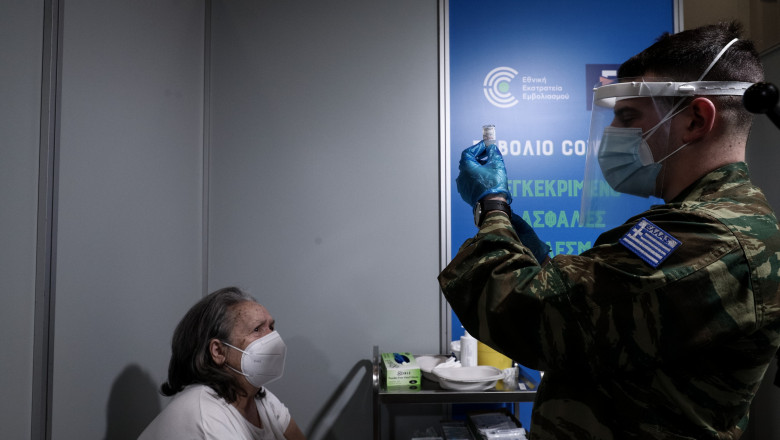 un medic militar din grecia care vaccineaza o persoana in varsta