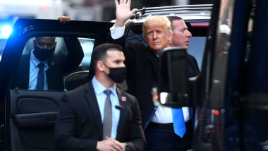 Donald Trump salută mulțimea înainte de a se urca în mașină.