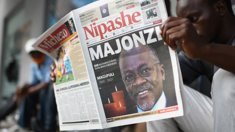 Bărbat care citește un ziar, pe a cărui primă pagină este anunțată moartea președintelui tanzanian, John Magufuli