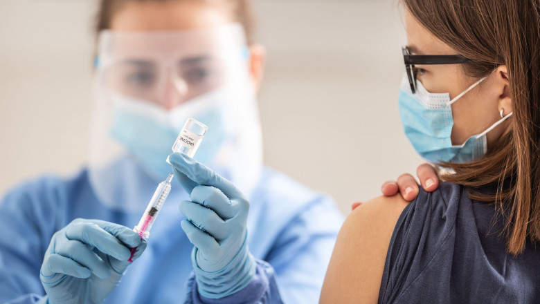 Un cadru medical umple o seringă cu ser pentru a vaccina o tânără.