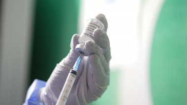 Un cadru medical umple o seringă cu vaccin dintr-o doză.