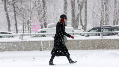 femeie pe strada in timp ce ninge