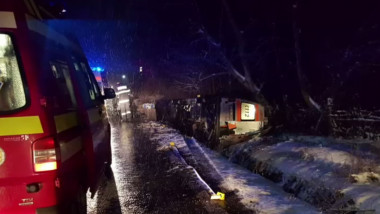 Ambulanță răsturnată în afara drumului.