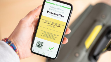 ilustratie certificat digital de vaccinare pe telefon tinut in mana