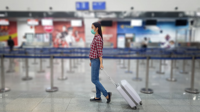o fata asiatica trage un troiler pe roti in aeroport