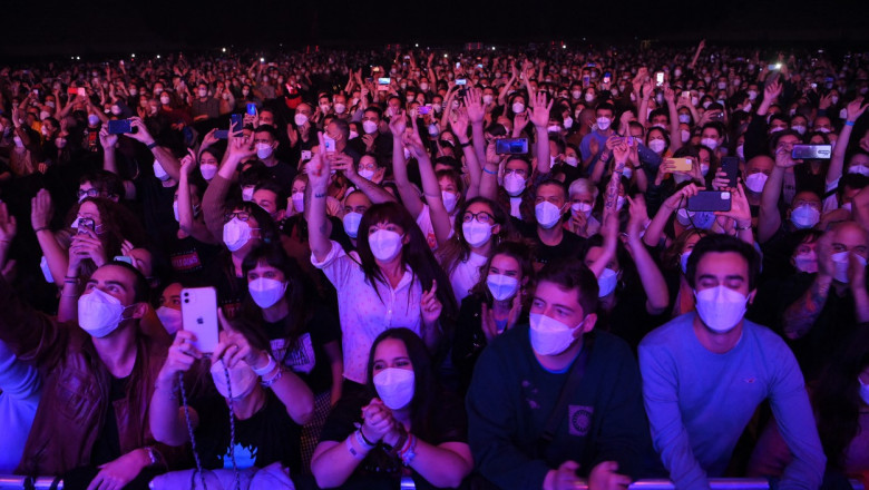 oameni cu masca la concert