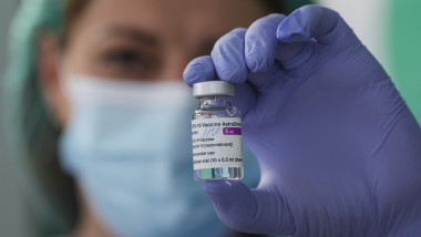 Un cadru medical ține în mână o doză de vaccin AstraZeneca.
