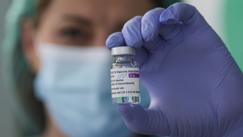 Un cadru medical ține în mână o doză de vaccin AstraZeneca.