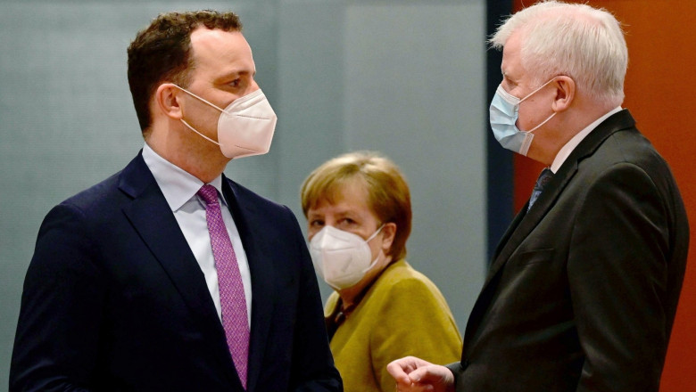Jens Spahn discuta cu Horst Seehofer, sub privirile Angelei Merkel