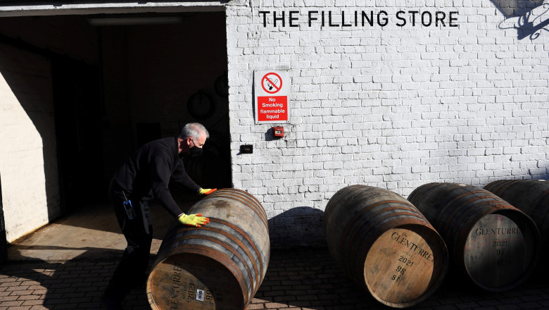 Butoaie cu whisky în faţa celei mai vechi distilerii de whisky din Scoţia