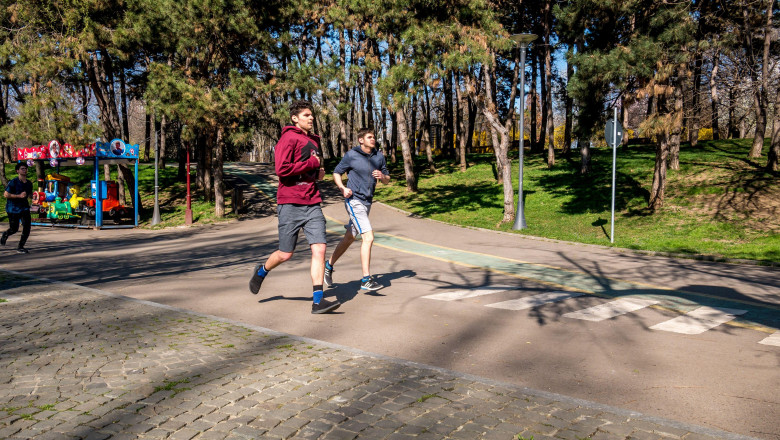 Tineri aleargă într-un parc din Bucureşti