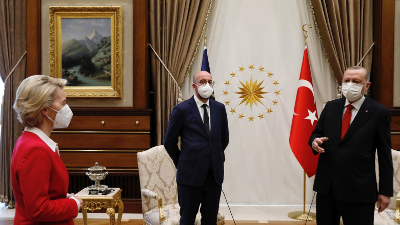 erdogan și charles michel stau în fața celor două scaune, în timp ce von der leyen se uita la ei