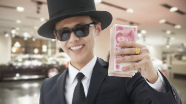 barbat din china arătând un teanc de bani