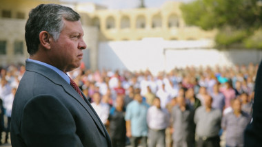 regele abdullah al iordaniei fotografiat din profil in fata unei multimi de oamni
