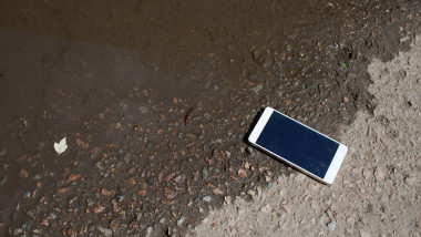 telefon mobil alb scapat langa un lac