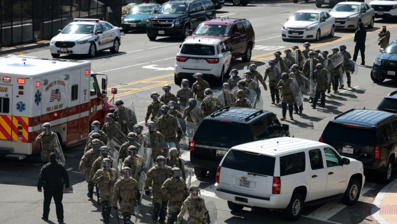 soldati din garda nationala printre masini si ambulanta